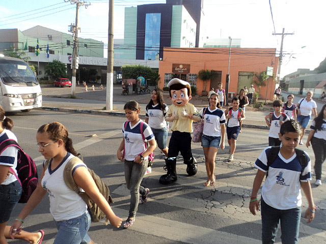 Agentes de trânsito orientam alunos a atravessar na faixa de pedestres